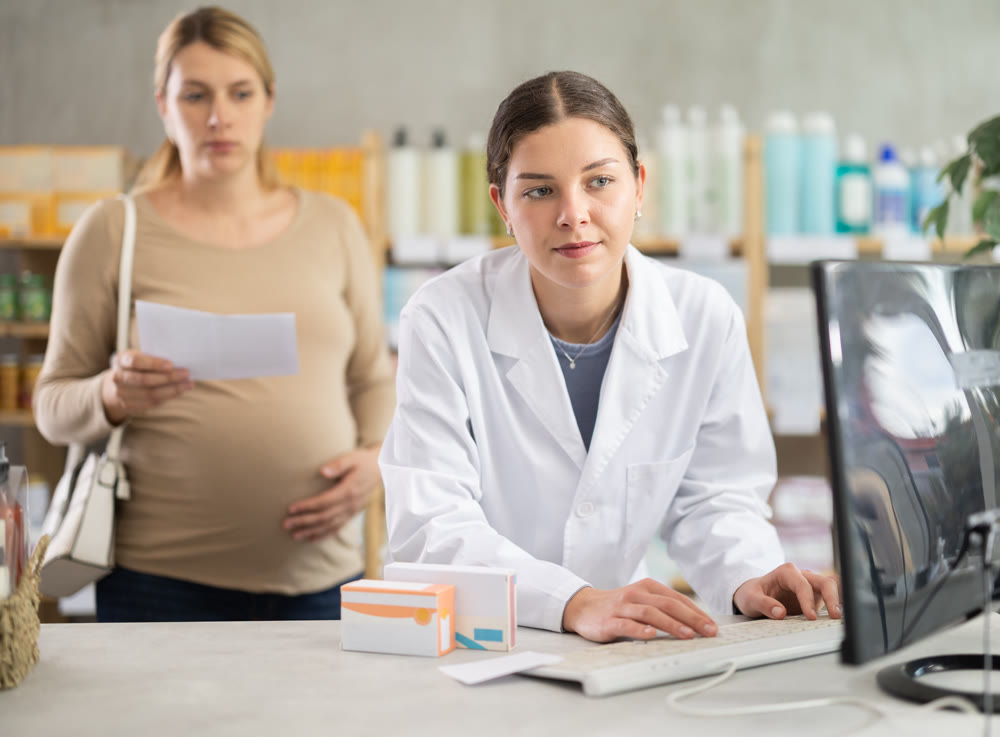 Pharmacist looking for prescription on computer for pregnant woman