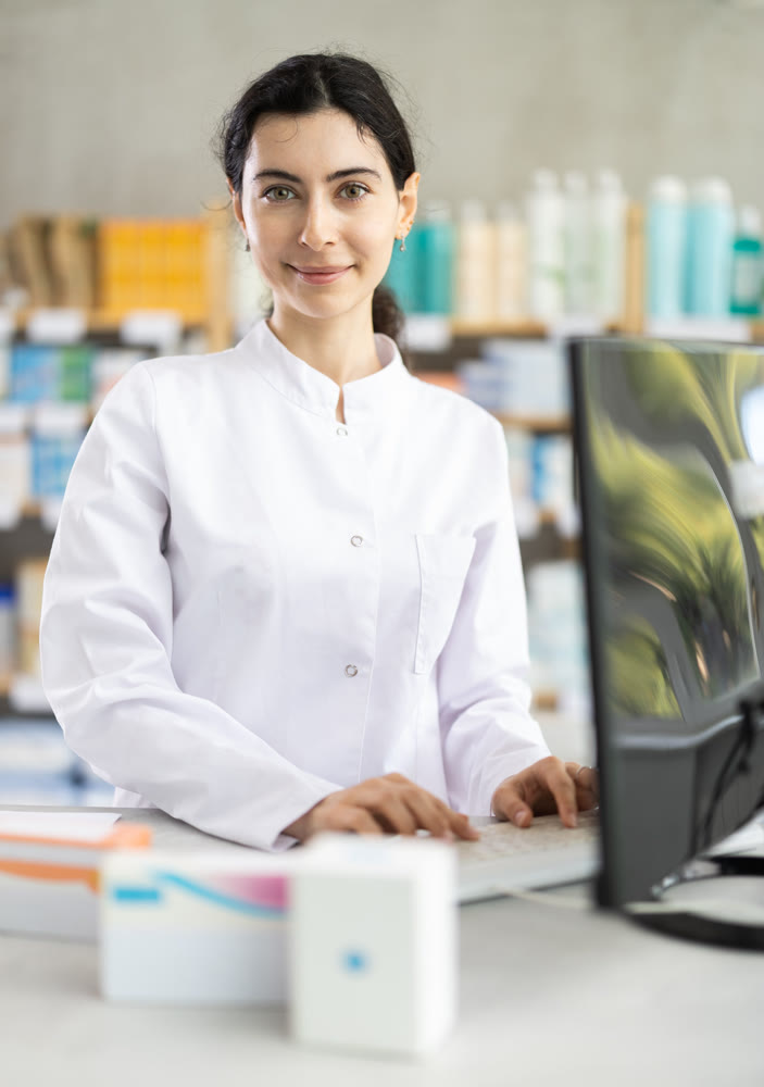 Female pharmacist working at computer in pharmacy