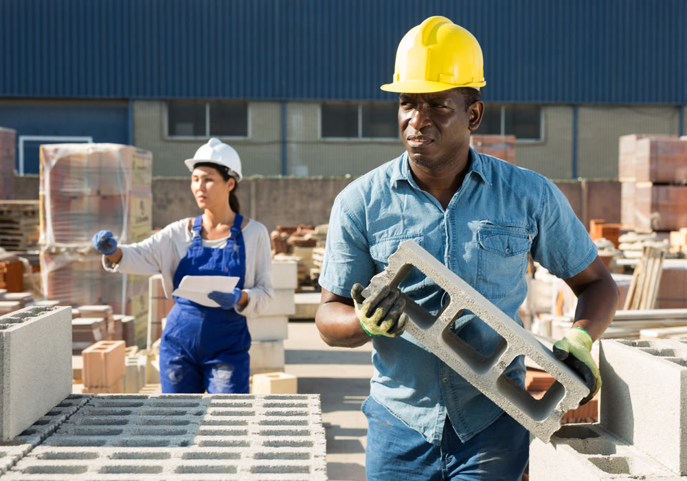 Man and woman working in outdoor construction material storage