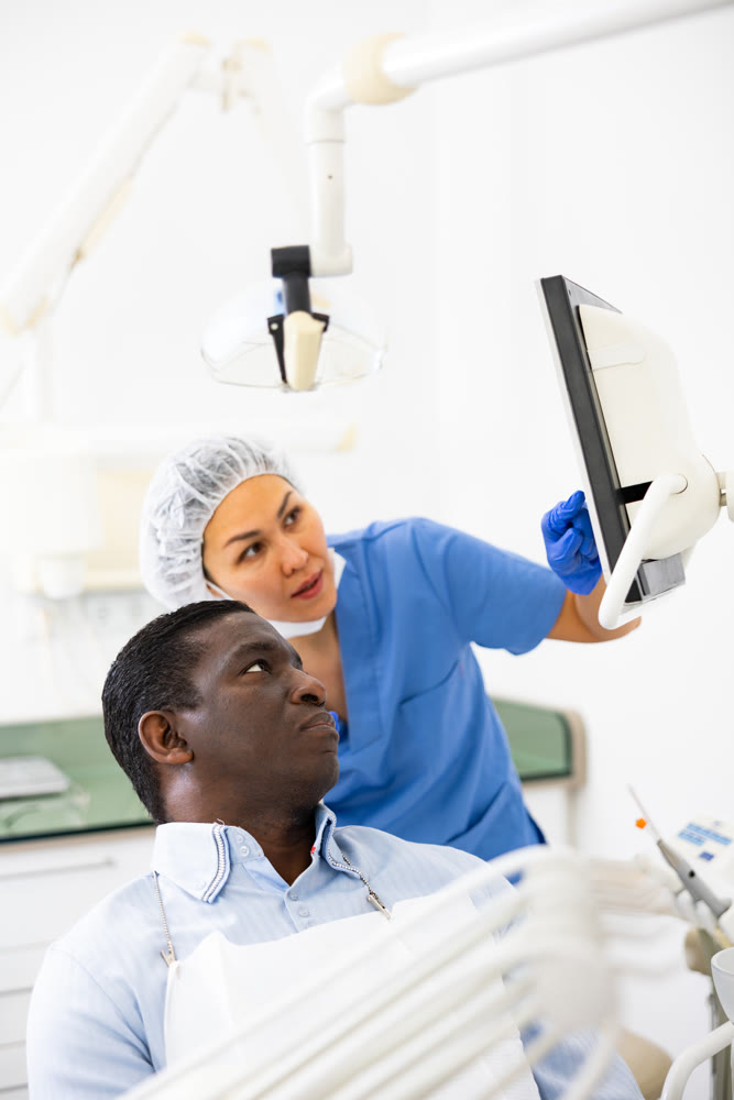 Doctor dentist shows the patient the result of dental x-ray
