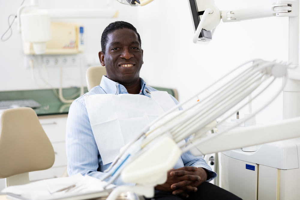 Smiling man in dental chair after surgery