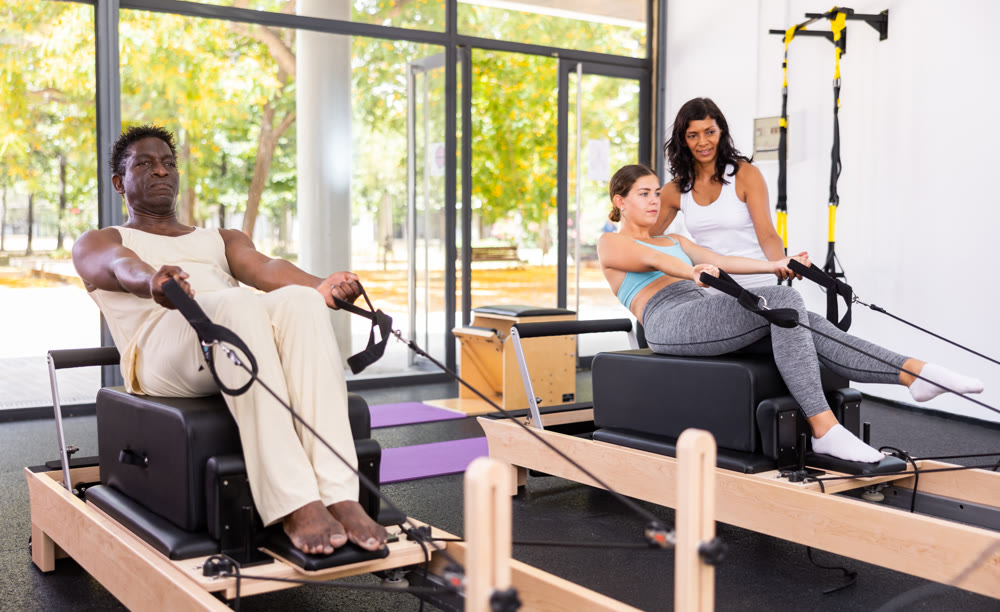 Attentive African American man practicing pilates on reformer