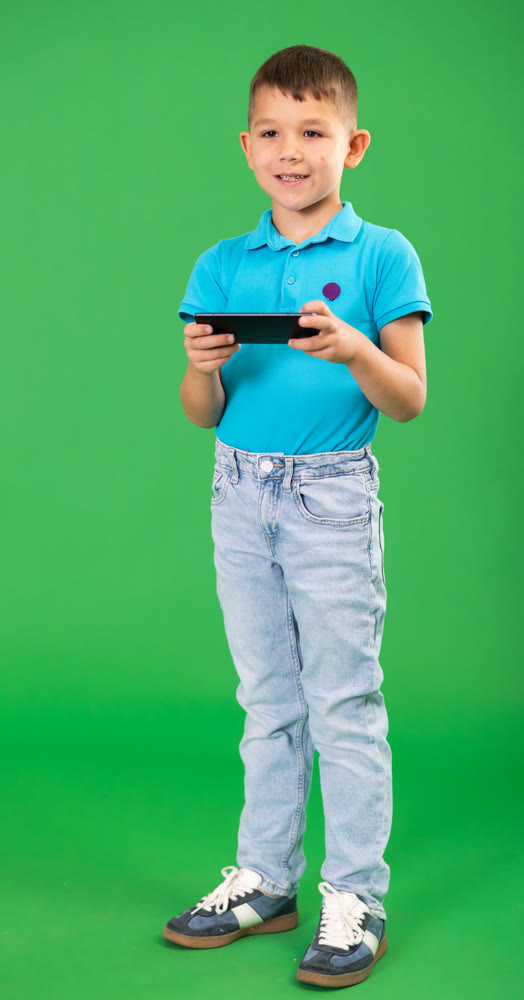 Chroma key compositing. Boy in blue clothes scrolling through smartphone screen against green screen background