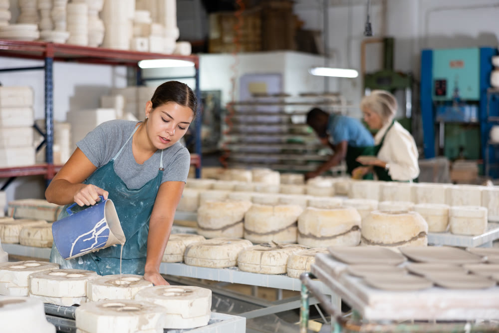 Woman ceramist working in pottery workshop