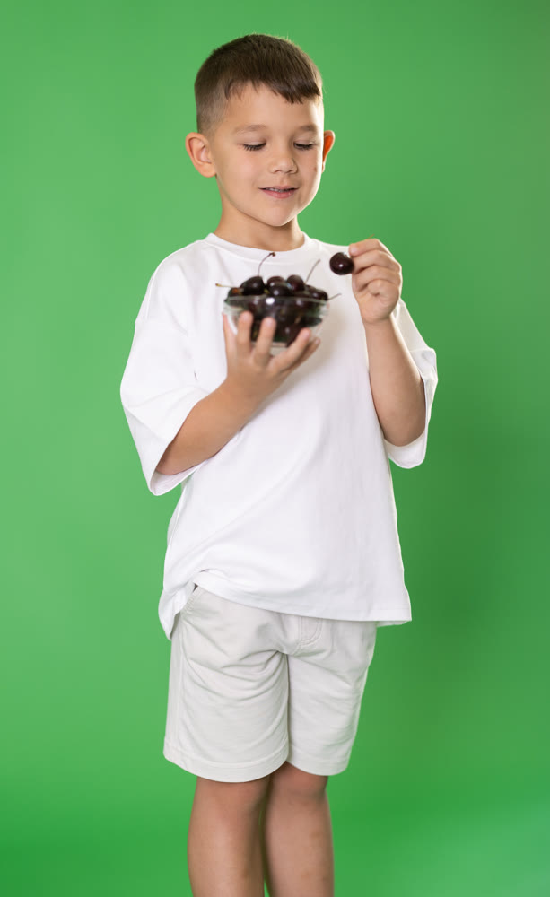 Boy eats cherries, summer plot