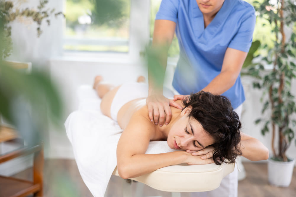 Portrait of woman relaxing on massage table at spa center