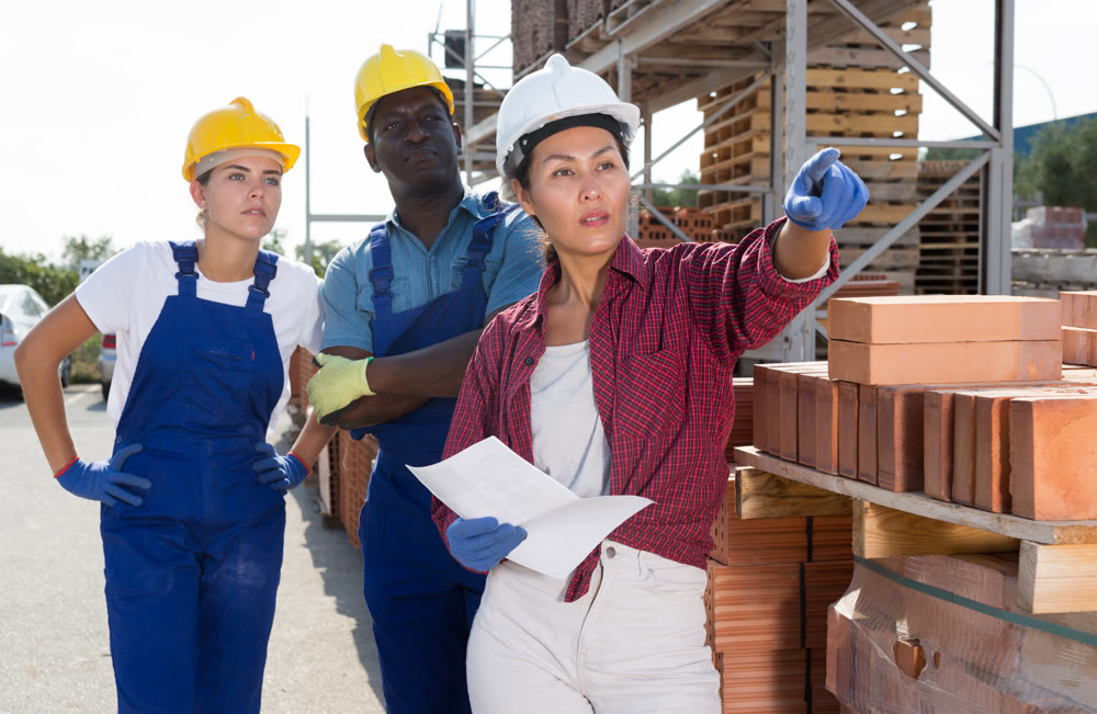 Group of workers discussing order list at warehouse