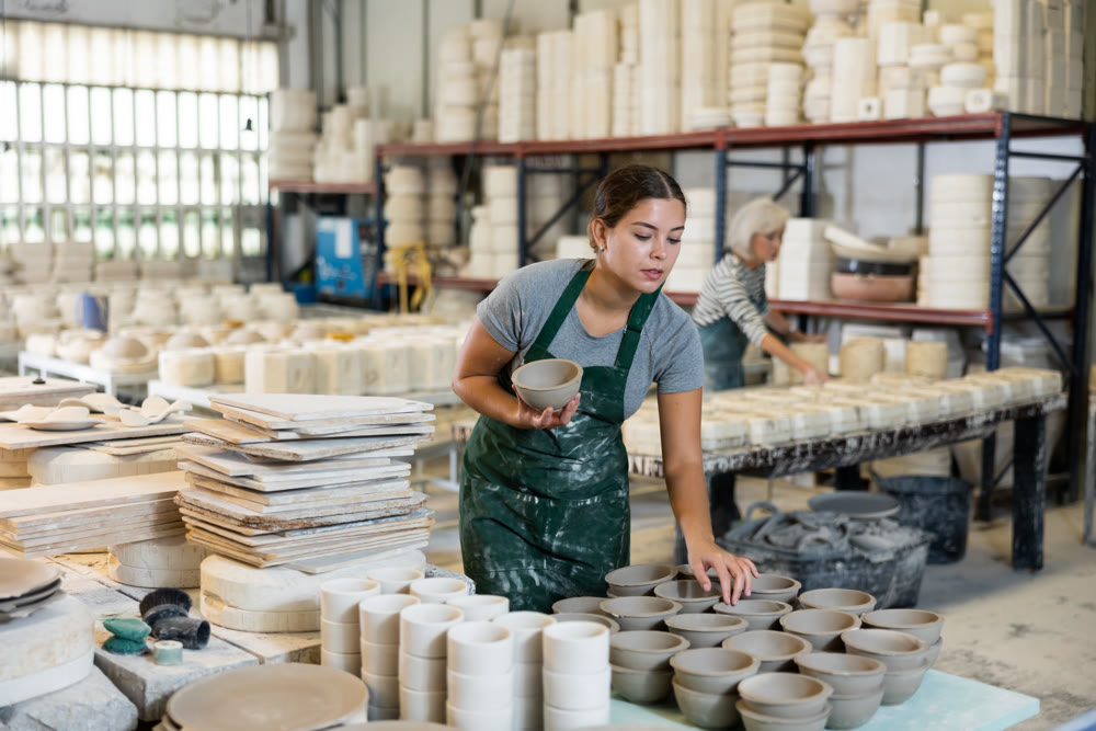 Female potter arrange pottery plate at factory ceramic