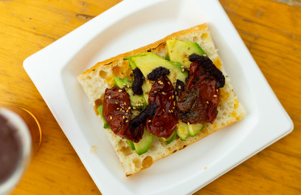 Avocado sandwich on baguette with baked bell peppers and fig jam