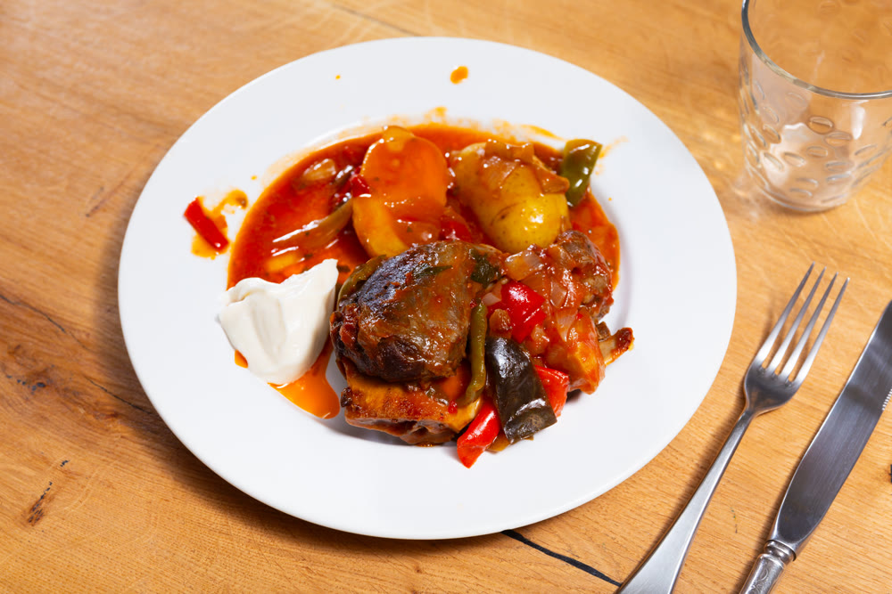 Stewed pork cheeks with vegetable sauce and jacket potatoes