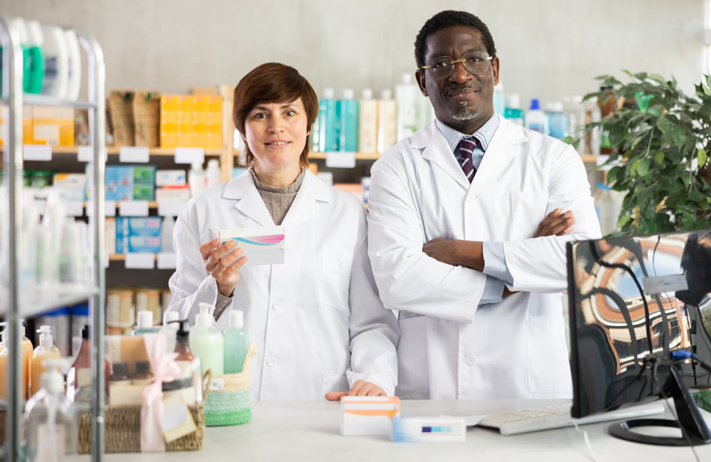 Woman pharmacist and African man assistant is waiting for client in drugstore