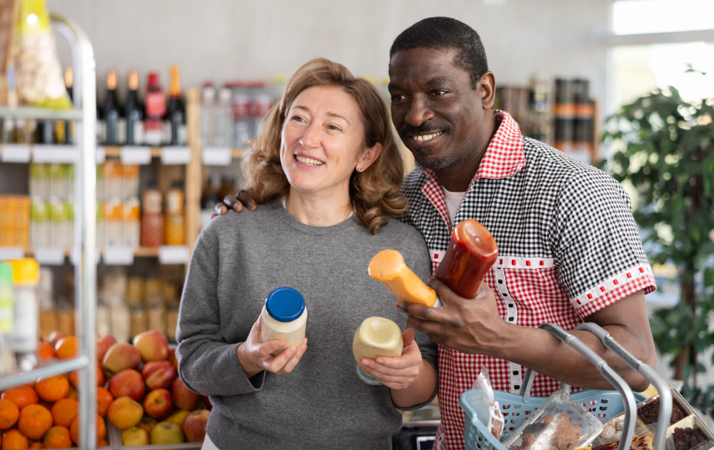 Couple buying various sauces and mayonnaise in grocery supermarket
