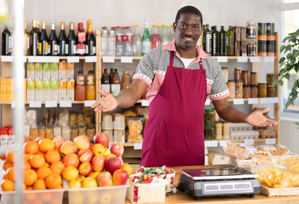Adult man seller at counter in grocery store