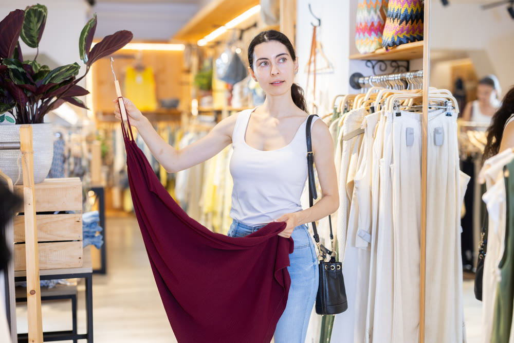 Girl customer chooses skirt in branded store