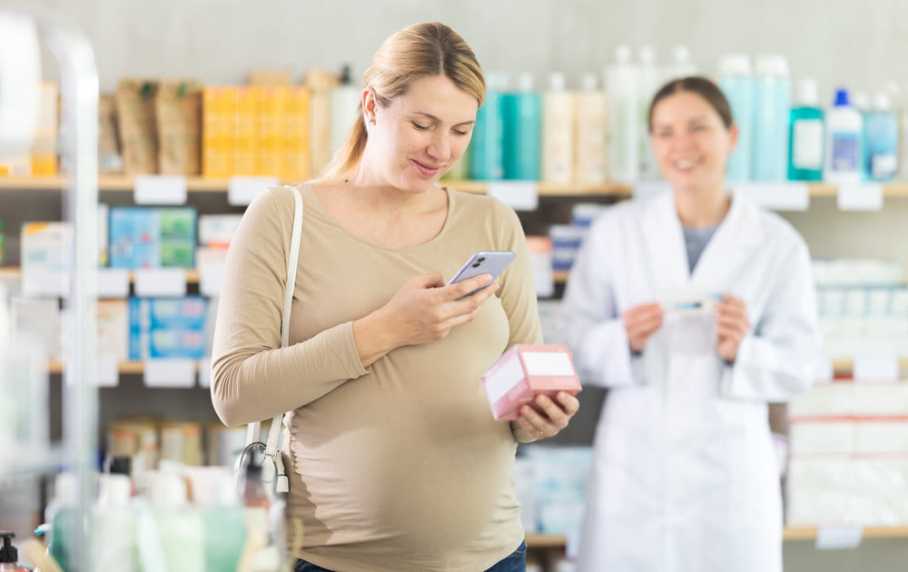 Pregnant woman scan QR code on vitamin pills product, pharmacist offer similar product in background
