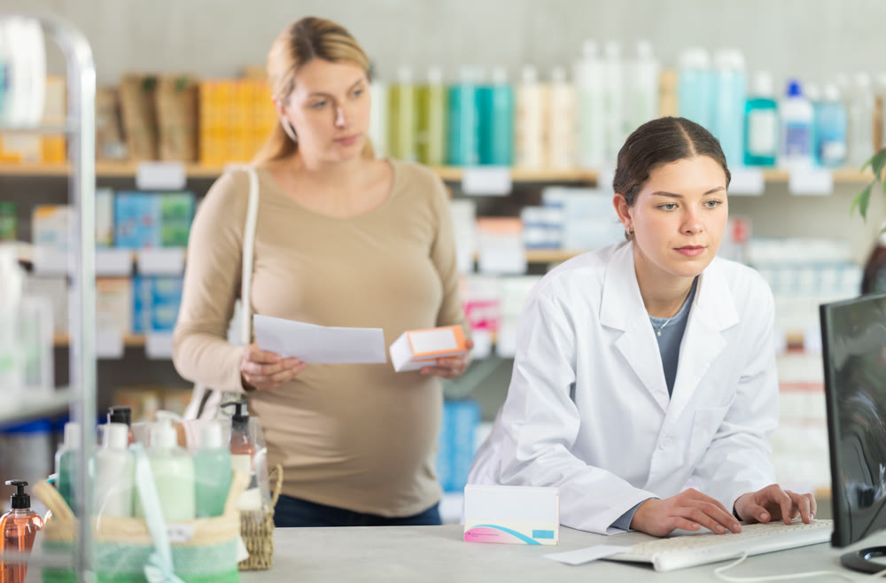 Pharmacist looking for prescription on computer for pregnant woman
