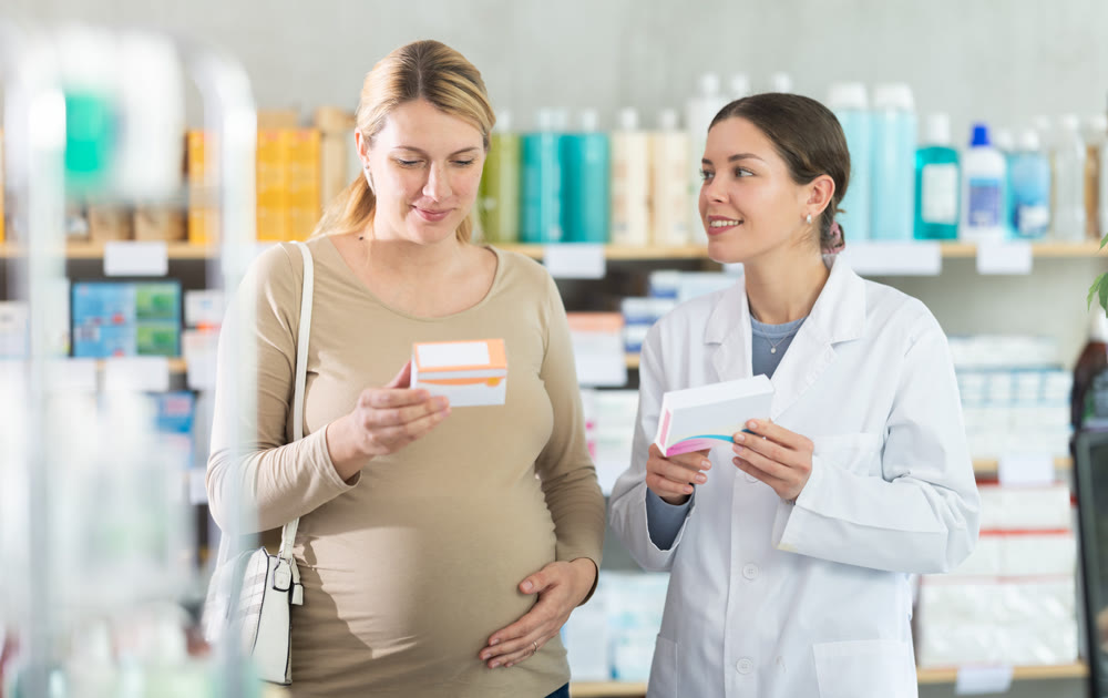 Pharmacist consulting pregnant woman on medication safety