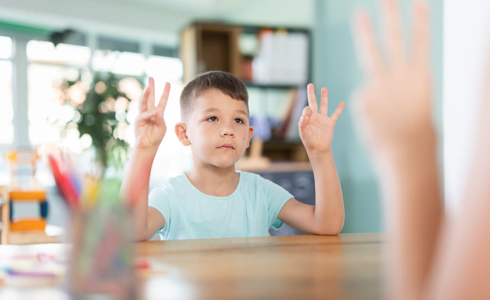Little boy repeating finger movements of child psychologist