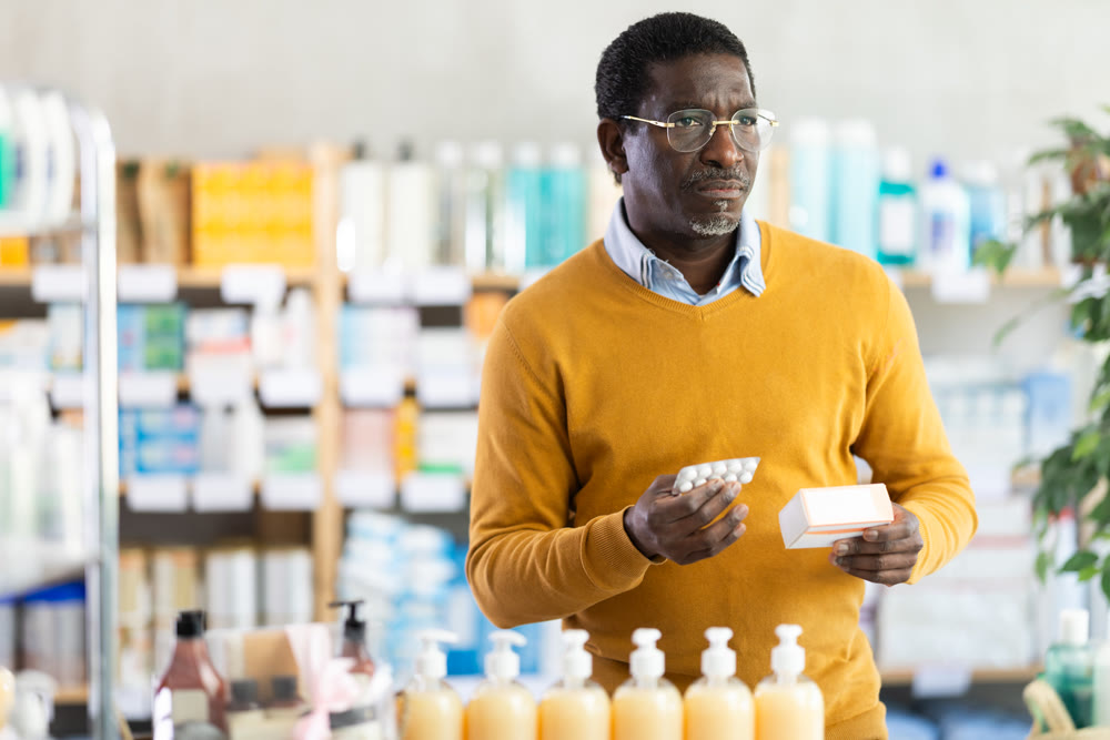 Adult man chooses pills at pharmacy