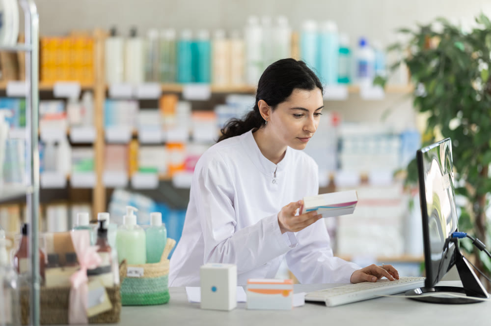 Woman pharmacist looking for pills on computer