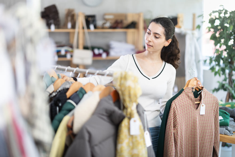 Armenian woman choosing clothes for autumn and winter in the store