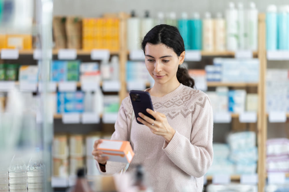 Young woman scanning qr code of pills
