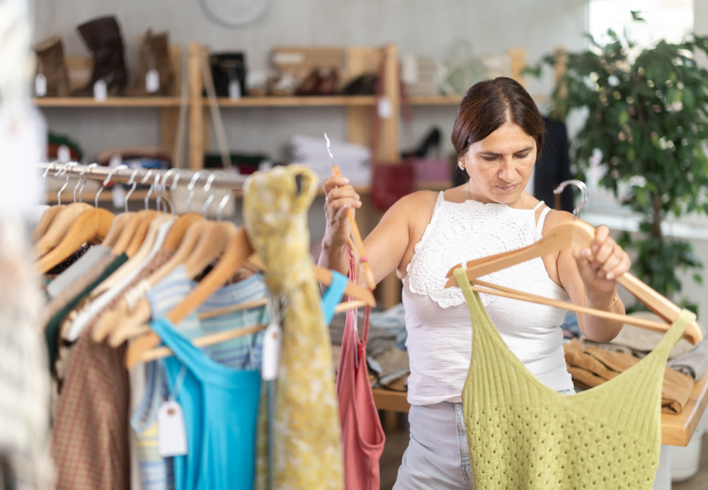 Latin woman customer turn over and choose something summer cloth in store,
