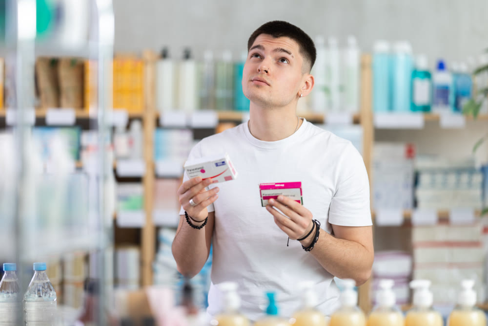 Young man buys paracetamol pills at pharmacy