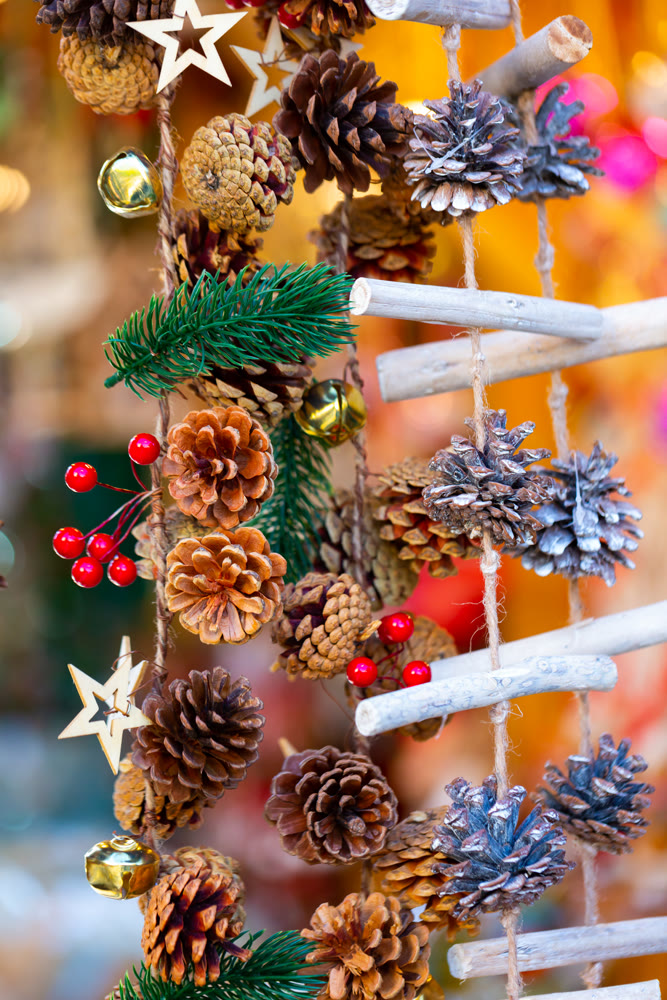Christmas background with wooden garland decorations at outdoors market closeup