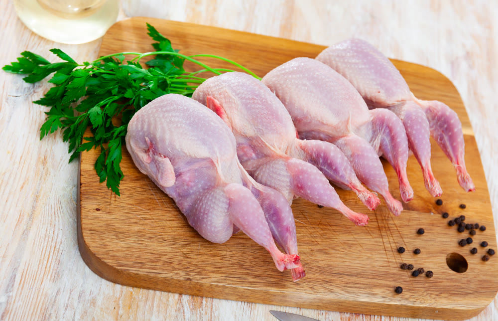 Fresh raw meat quails ready for cooking on slate board
