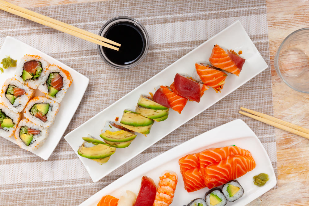 Variations of sashimi and sushi with soy sauce on table