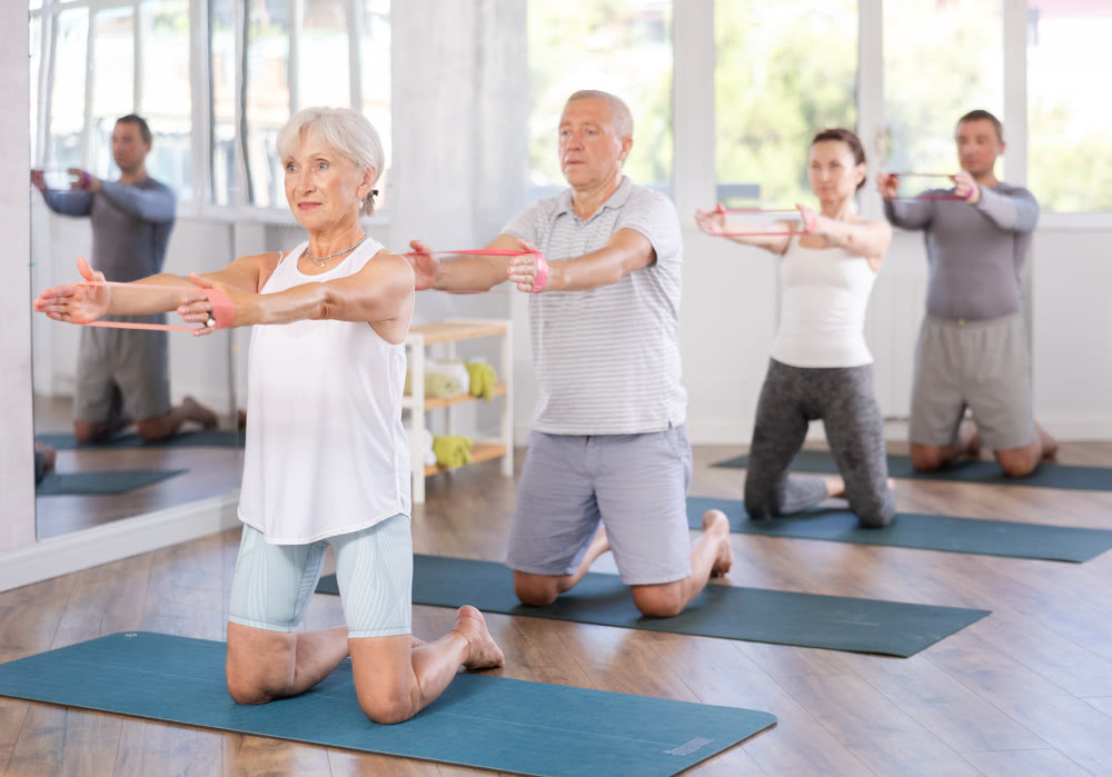 Elderly woman exercises with pilates band
