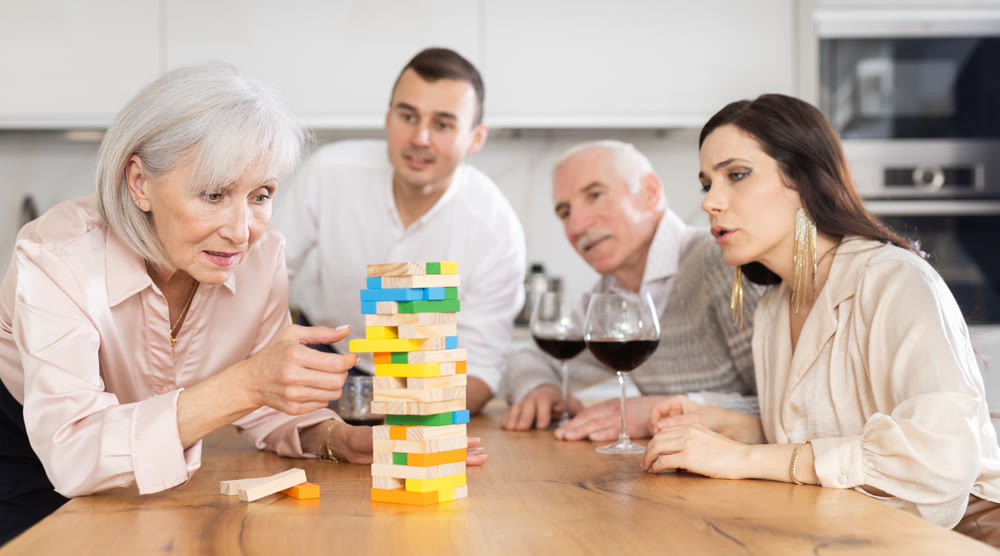 Elderly woman enjoying tower building game during family weekend