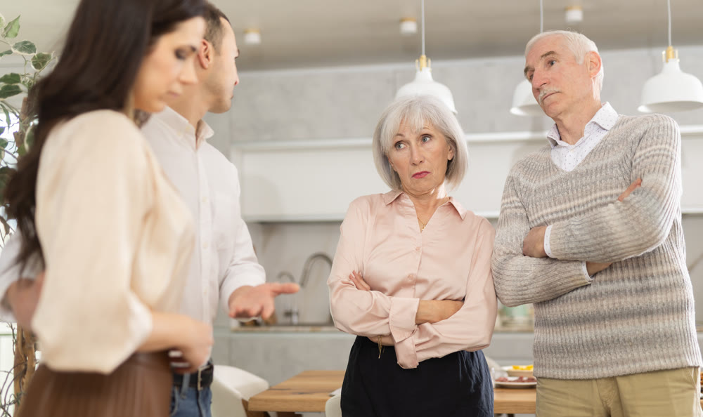 Young man presenting girlfriend to disapproving elderly parents