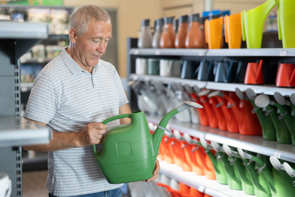 Elderly man chooses watering can in store