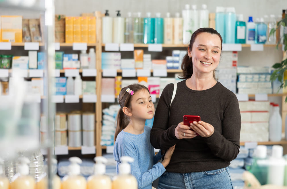 Woman with phone with her daughter chooses medicines