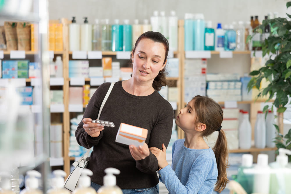 woman and her daughter choose pills at the pharmacy