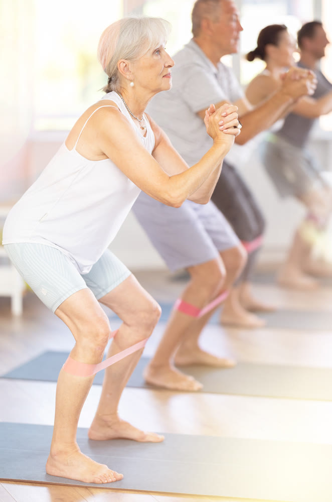 Elderly woman exercises with pilates band