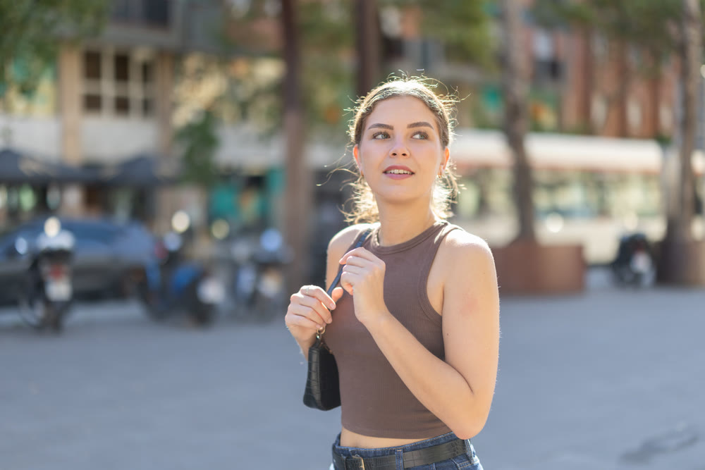 Young woman walks along city street