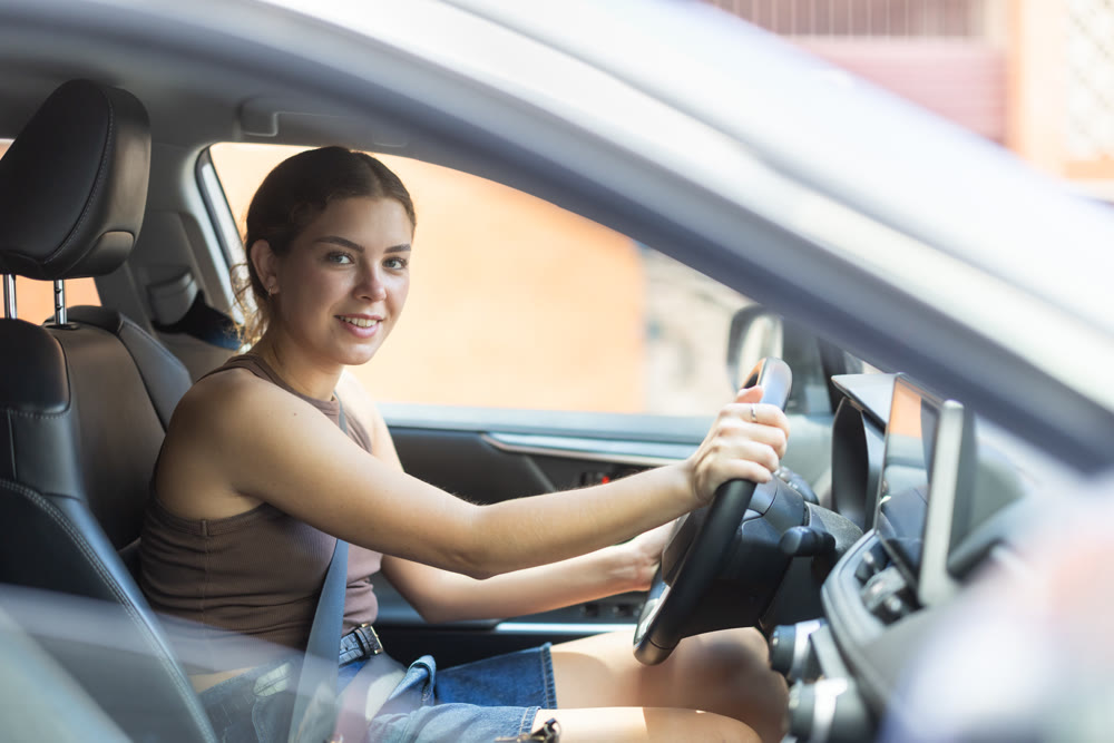 Young woman driving car during daytime commute