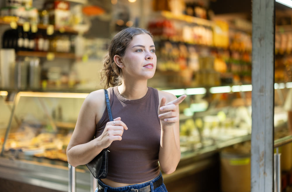 Girl is walking around street market or fair, choosing food goods