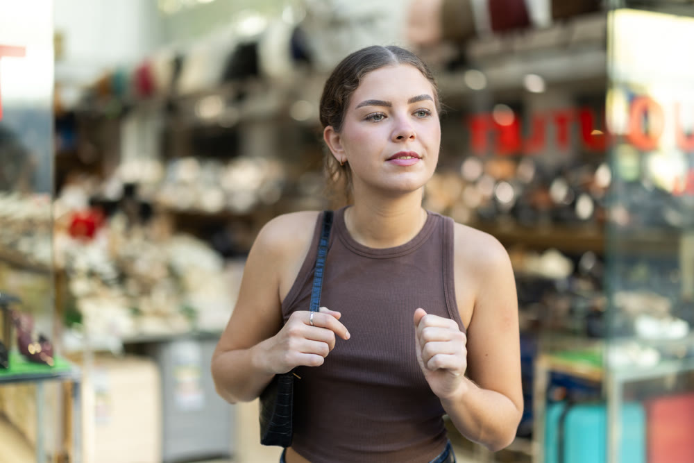 Woman looking at footwear store window display street