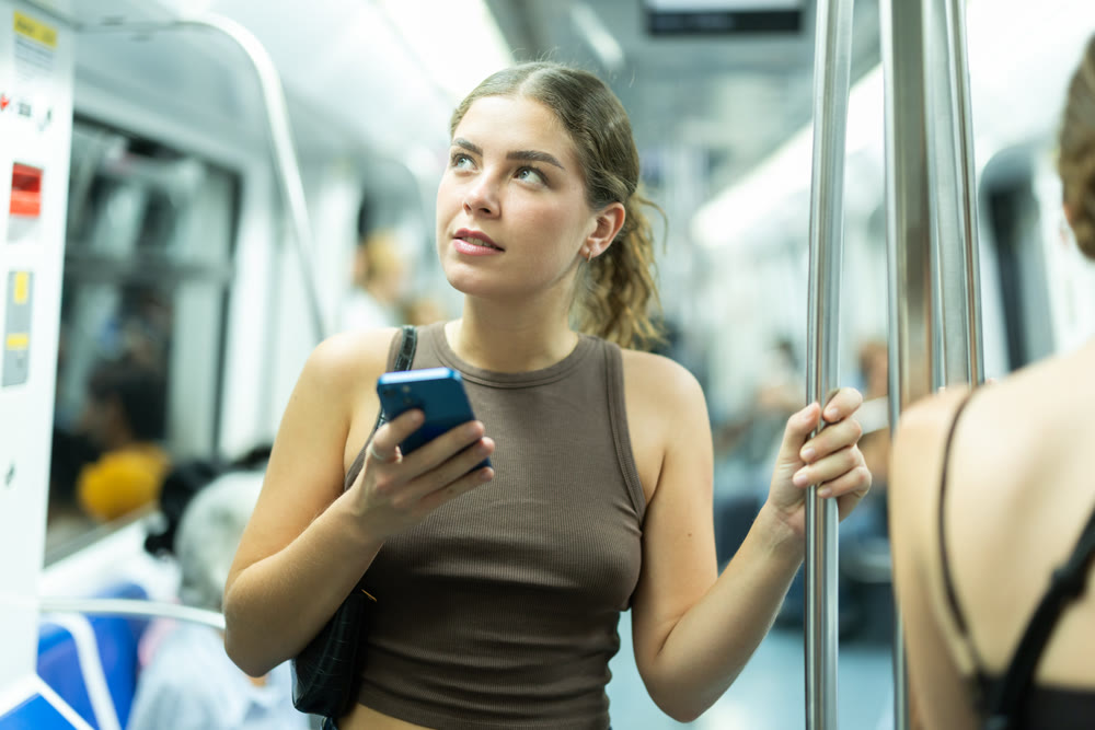Girl is riding subway with mobile phone