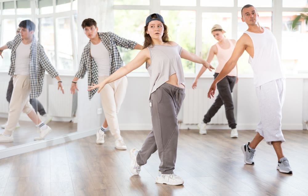 Young girl practicing basic hip hop steps in training hall