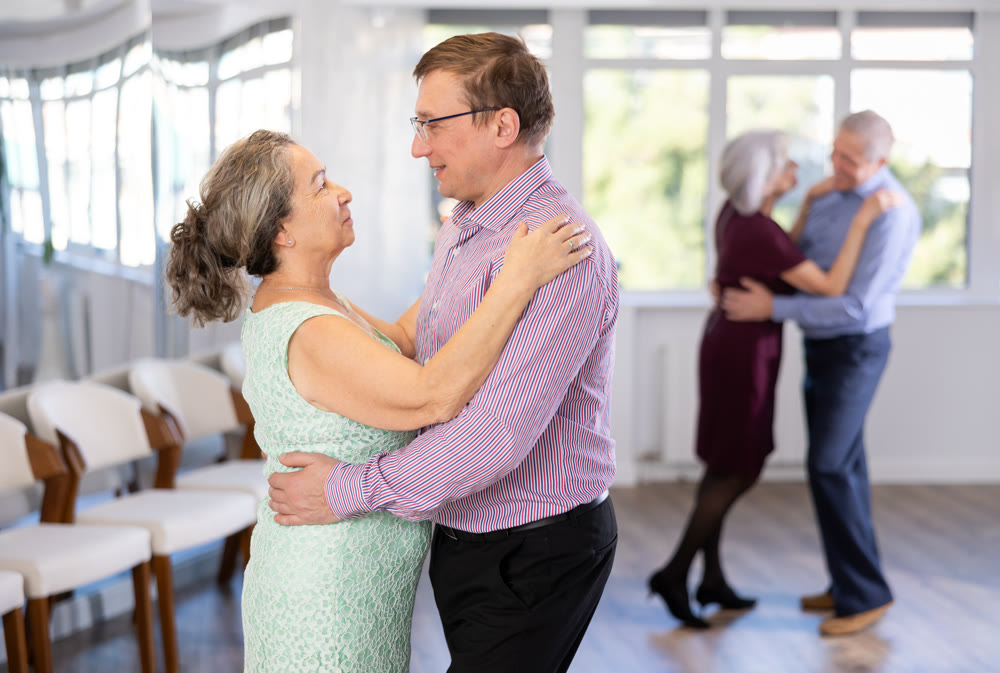 Adult man and elderly woman dance waltz