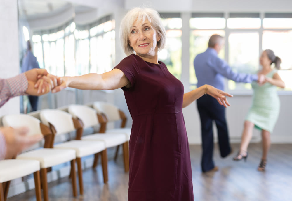 Elderly woman dancing twist with her partner