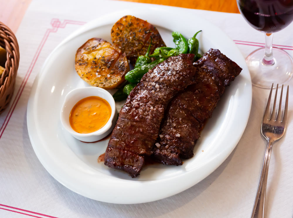 Grilled flank steaks with potatoes, jalapenos and chimichurri sauce