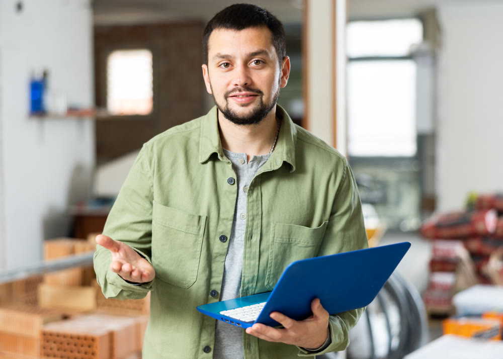 Civil engineer monitors the process of capital repairs on a laptop
