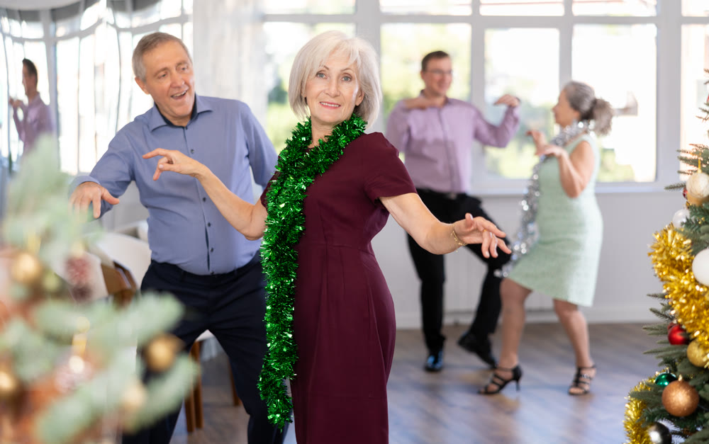 Senior man and elderly woman are dancing contemporary twist in couple in New Year studio atmosphere