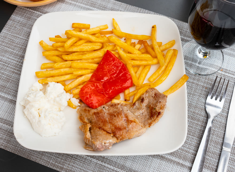 Fried pork with French fries and pepper